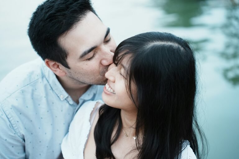 Man kissing woman on the cheek outdoors