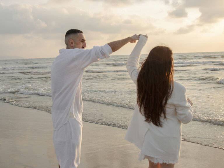 a man and a woman dancing on the beach